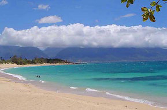 Long sandy beach with turquoise water and West Maui mountains
