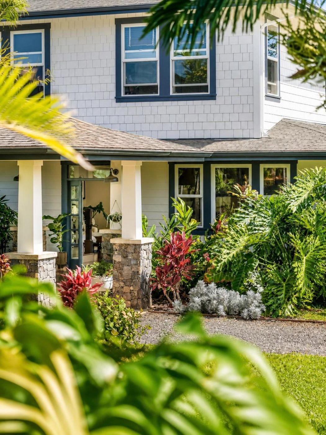 Front porch framed by palms and red ti plants