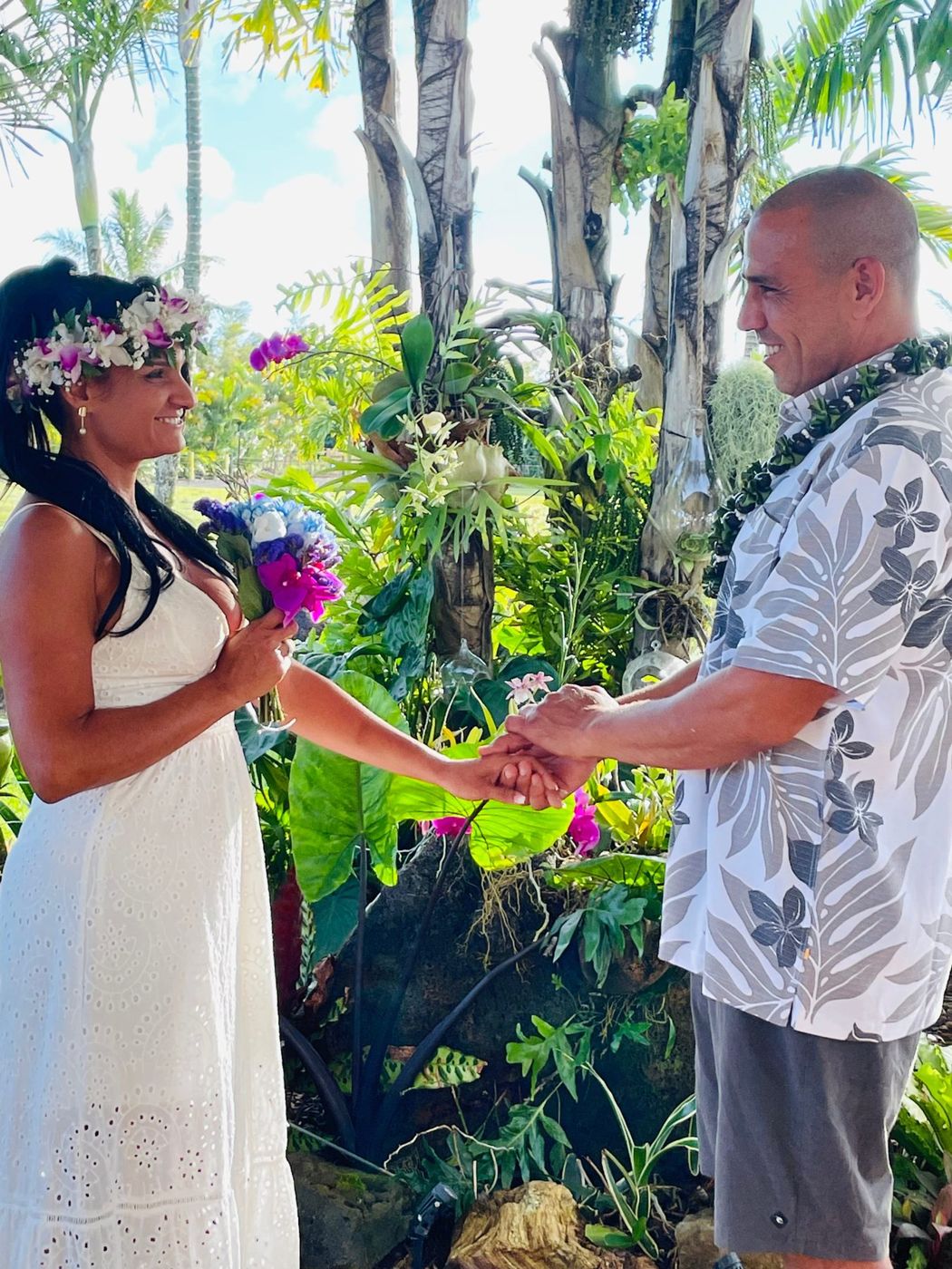 Lizya and Claudio on their wedding day in a tropical garden