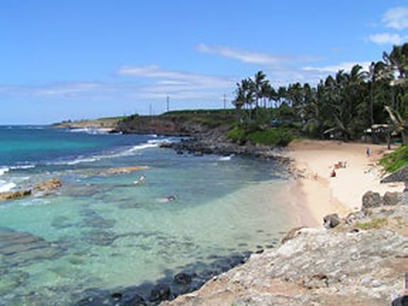 Small sandy cove with a rock pool next to Mama’s Fish House